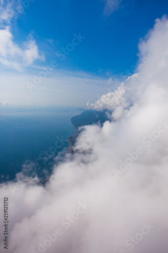 high flight against the wall of clouds over the blue sea view of a paraglider pilot, summer vacation in the Caucasus in Abkhazia. © Mikhail Semenov