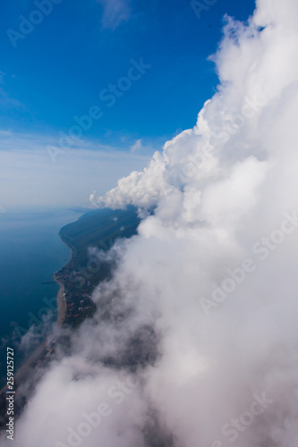 high flight against the wall of clouds over the blue sea view of a paraglider pilot, summer vacation in the Caucasus in Abkhazia.