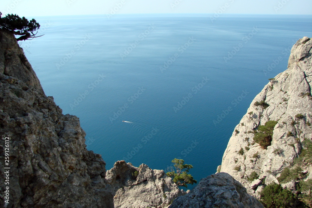 The landscape from the altitude of the rock of various shades of sea blue, connected on a horizon with the purity of the blue sky.
