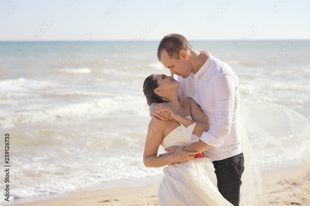 Young adult wedding couple kissing near the sea Young adult wedding couple kissing near the sea