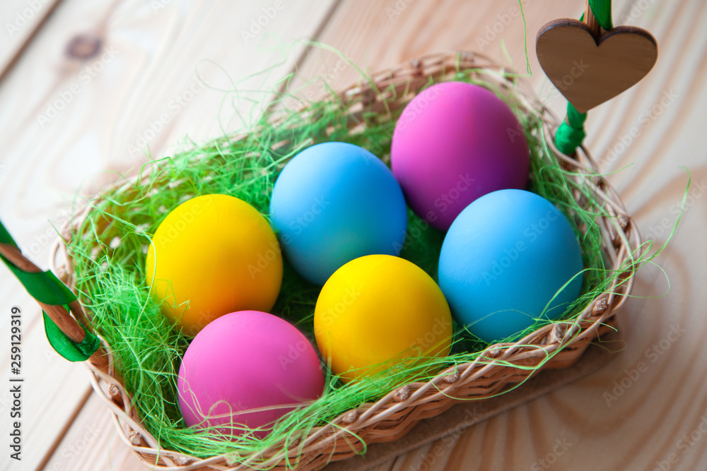 colored chicken eggs in a basket