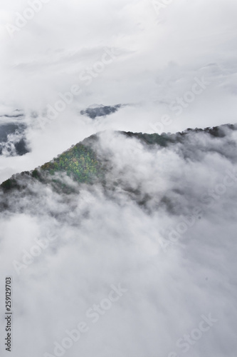 Over the forest hills. Flying above the clouds (sea of clouds) foggy view from a great height Aerial view from a height in in Abkhazia