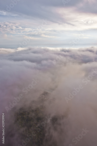 The sun shines through the clouds. Flying above the clouds (sea of clouds) foggy view from a great height Aerial view from a height in in Abkhazia © Mikhail Semenov