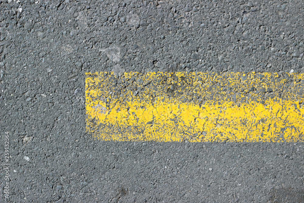 Fototapeta premium Asphalt surface texture detail with old parking yellow paint