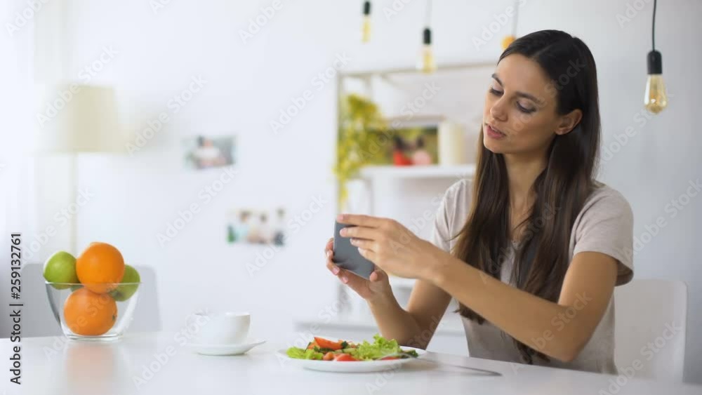 Young food blogger making salad photos on phone, posting in social networks Young food blogger making salad photos on phone, posting in social networks