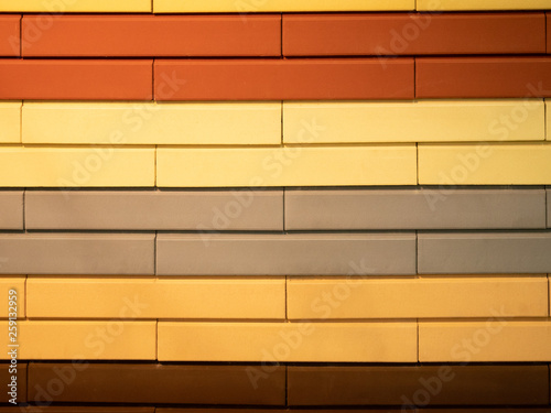 abstract pattern wall made of different colors bricks - orange  red  brown  gray and yellow