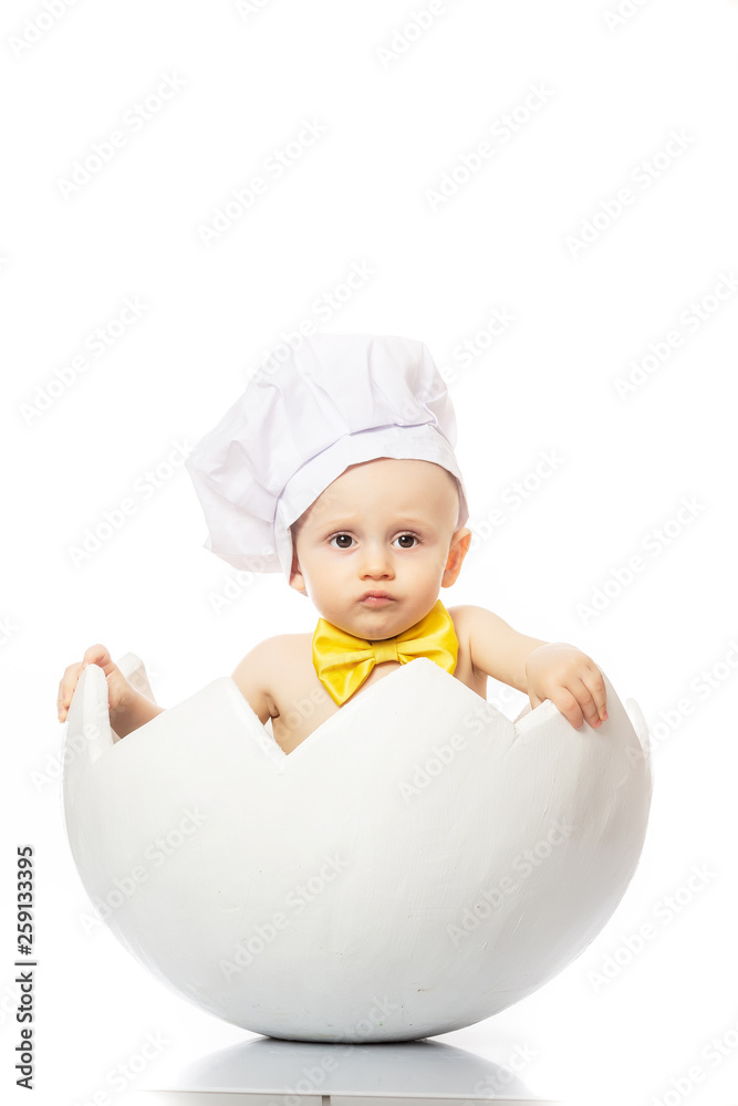 Portrait of a little adorable infant baby sitting in egg shell. Little Chef. isolated on white Portrait of a little adorable infant baby sitting in egg shell. Little Chef. isolated on white