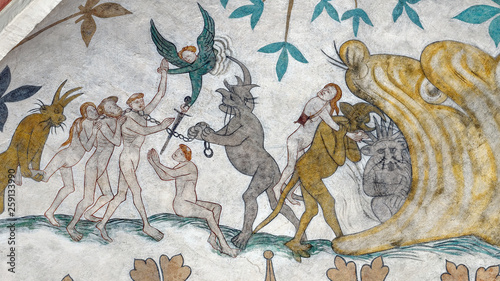 Medieval hell scene from Odsherred Church in Denmark. An angel is fighting the chains of the demons dragging sinners  into the flaming jaws of hell where the devil himself resides