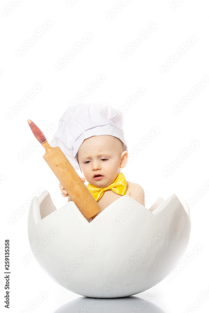 funny portrait infant cook baby portrait wearing chef hat, yellow butterfly with dough rolling pin, sitting in egg shell isolated on a white background funny portrait infant cook baby portrait wearing chef hat, yellow butterfly with dough rolling pin, sitting in egg shell isolated on a white background