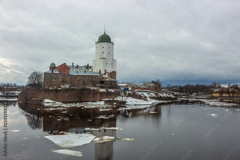 Old fortress on an island in Vyborg, reflection in the water of the Bay and clouds