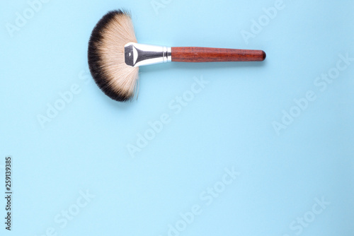 makeup brushes on a blue background. Top view, flat lay, copy space