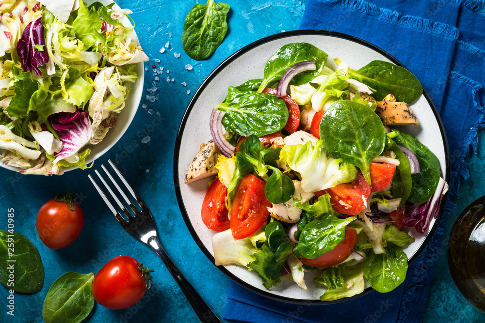 Green salad with chicken and vegetables top view. Green salad with chicken and vegetables top view.