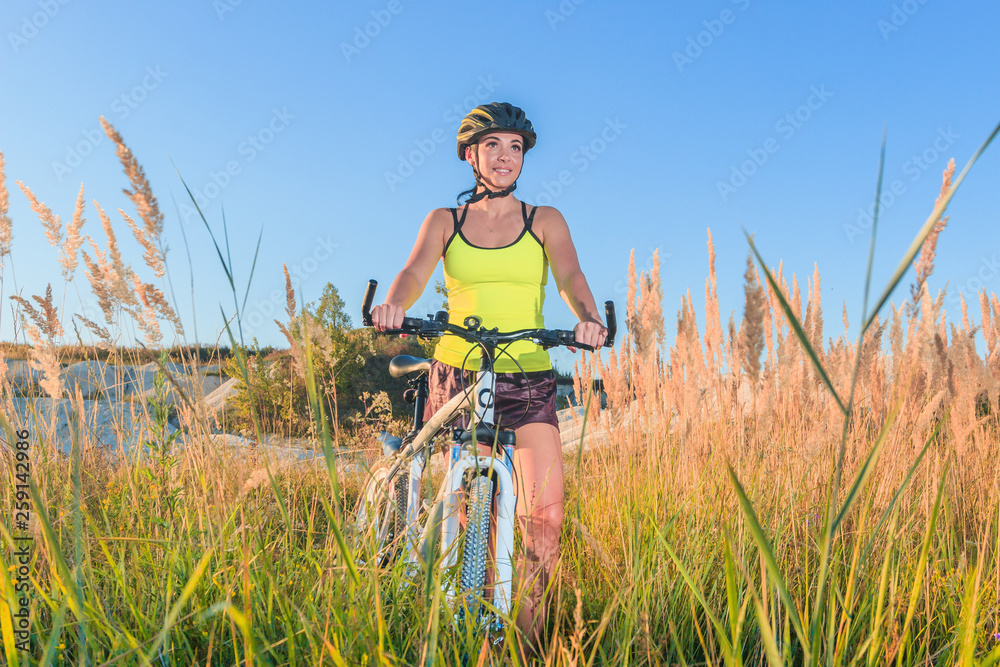 Young sporty woman with a bike, soft focus background Young sporty woman with a bike, soft focus background