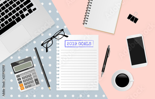 2019 goals text on white note paper with office supplies on pastel background