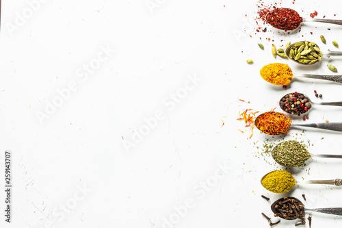Fototapeta Naklejka Na Ścianę i Meble -  Set of indian spices in spoons on white