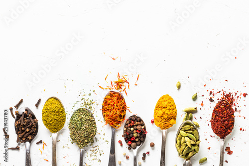 Fototapeta Naklejka Na Ścianę i Meble -  Set of indian spices in spoons on white