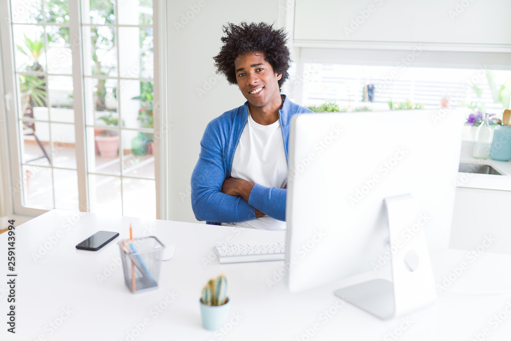 African American man working using computer happy face smiling with crossed arms looking at the camera. Positive person.