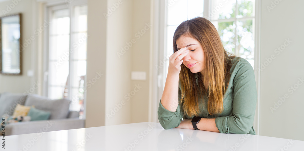 Beautiful young woman at home tired rubbing nose and eyes feeling fatigue and headache. Stress and frustration concept. Beautiful young woman at home tired rubbing nose and eyes feeling fatigue and headache. Stress and frustration concept.