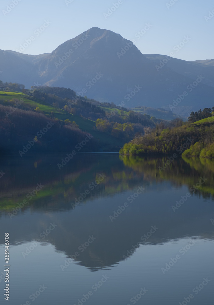 mountain in morning light reflected in calm waters of lake, Txindoki, Euskadi