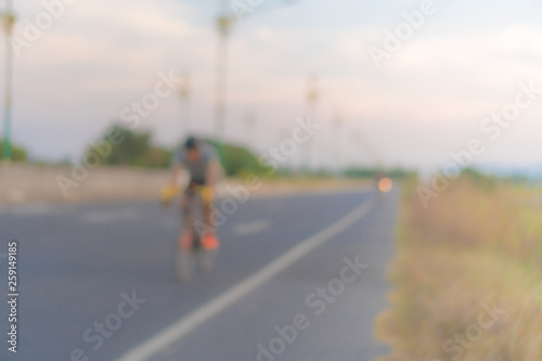 People ride bicycle in evening with sunset and sunlight.