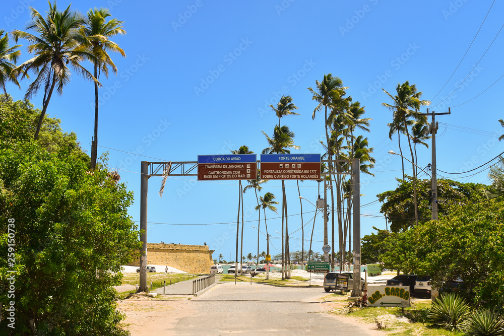 Ilha de Itamaraca, Brazil - Circa January 2019: Road signs with tourist information in Portuguese at the entrance of popular Fort Orange beach
