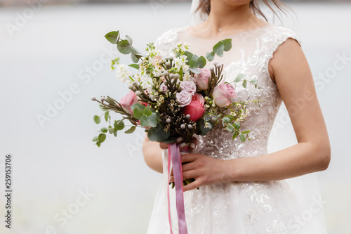 beautiful wedding bouquet. Stylish wedding bouquet bride of pink roses, white carnation and green flowers. Side view. Wedding decor.
