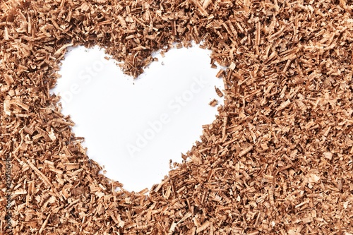 heart-shaped and wood saw dust on dirty white background
