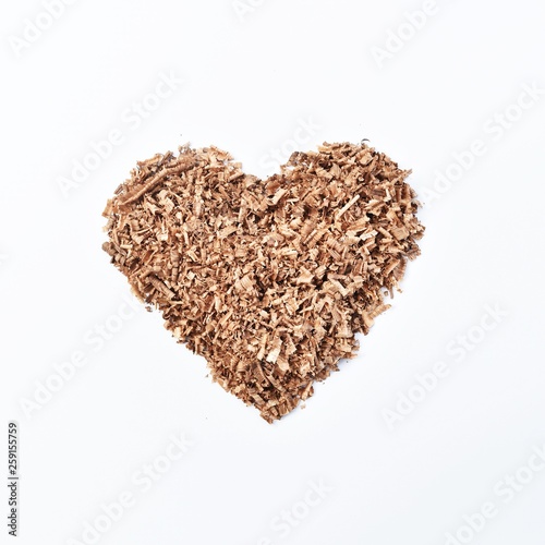 heart-shaped wood saw dust on dirty white background