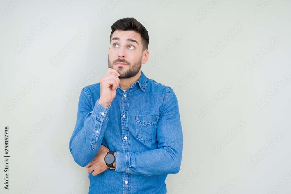 Young handsome man over isolated background with hand on chin thinking about question, pensive expression. Smiling with thoughtful face. Doubt concept. Young handsome man over isolated background with hand on chin thinking about question, pensive expression. Smiling with thoughtful face. Doubt concept.
