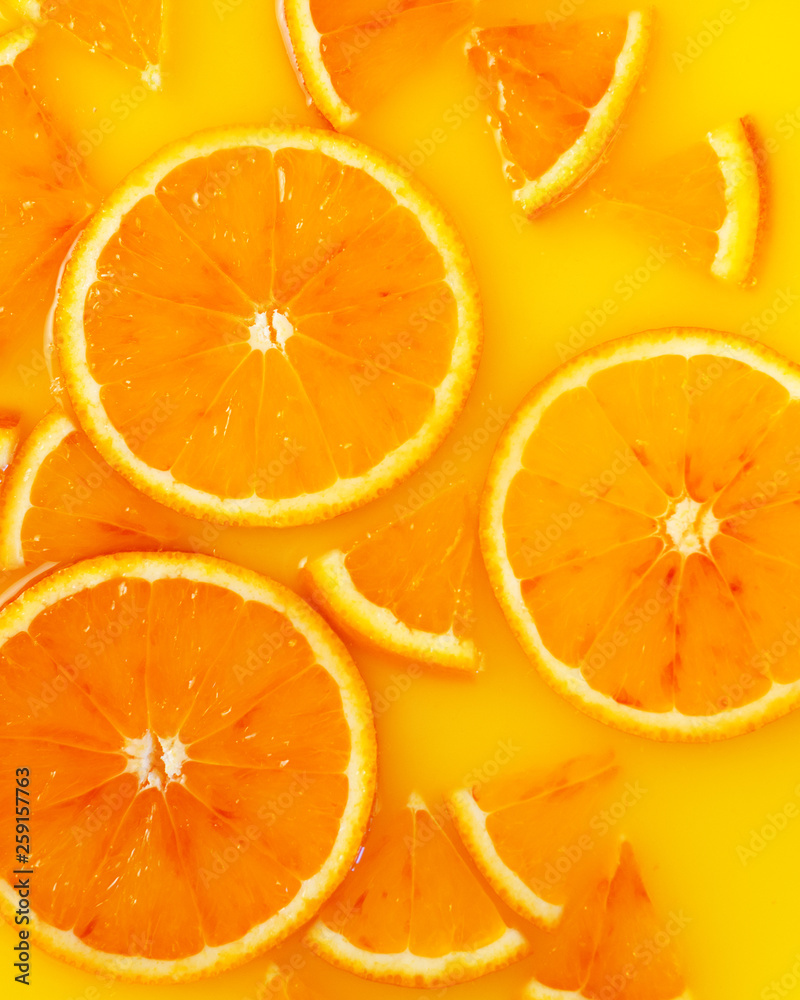 Top view of red orange slices in juice as background