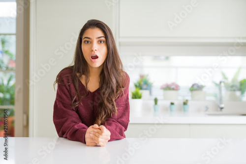 Young beautiful woman at home afraid and shocked with surprise expression  fear and excited face.