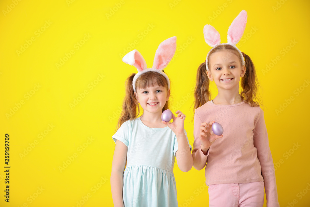 Cute little children with Easter eggs and bunny ears on color background Cute little children with Easter eggs and bunny ears on color background