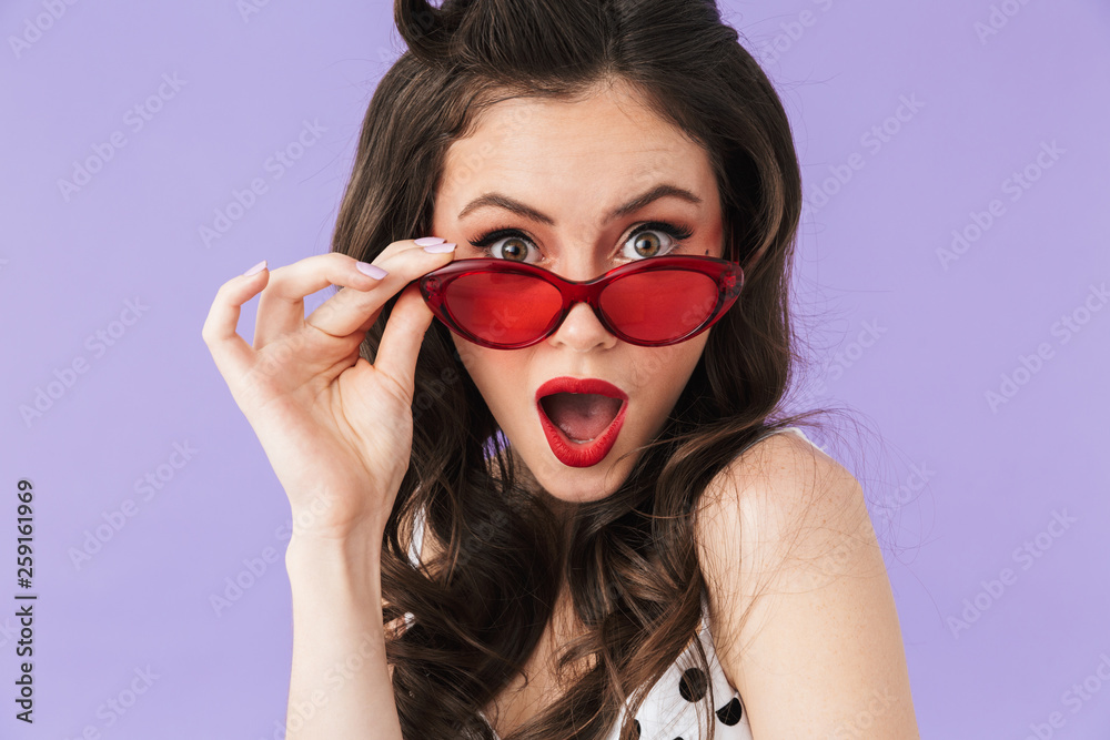Portrait of gorgeous pin-up woman 20s in vintage polka dot dress and retro sunglasses smiling at camera Portrait of gorgeous pin-up woman 20s in vintage polka dot dress and retro sunglasses smiling at camera