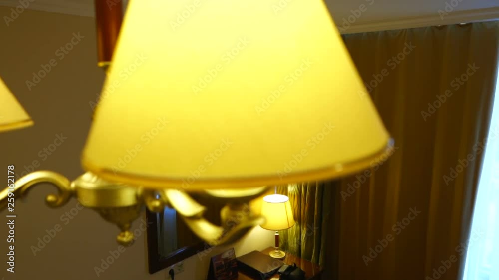 Classical 3 light gold bronze chandelier with shades hanging on ceiling in modern apartment or hotel room. Classical 3 light gold bronze chandelier with shades hanging on ceiling in modern apartment or hotel room.