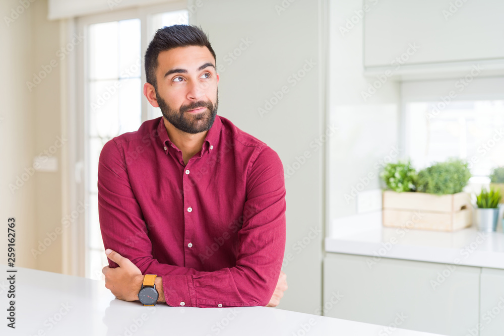 Handsome hispanic business man smiling looking side and staring away thinking.