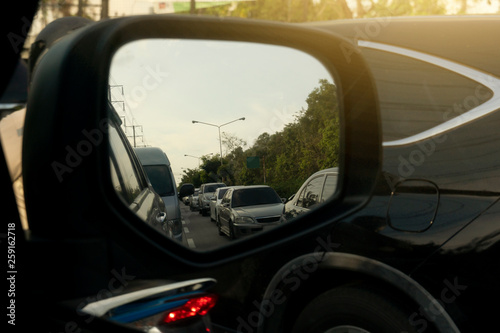 Evening road traffic convey stories from the car side mirror