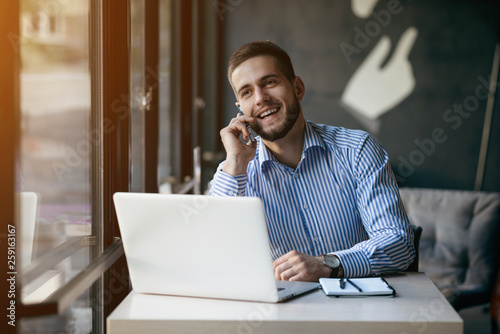 Young man drawing template for the web site associated with digital marketing, current trends and tendencies of UX / UI design. Businessman who rules his company remotely, like a freelancer