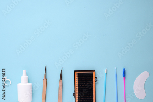 makeup brushes and cosmetics on a blue background. Top view, flat lay, copy space