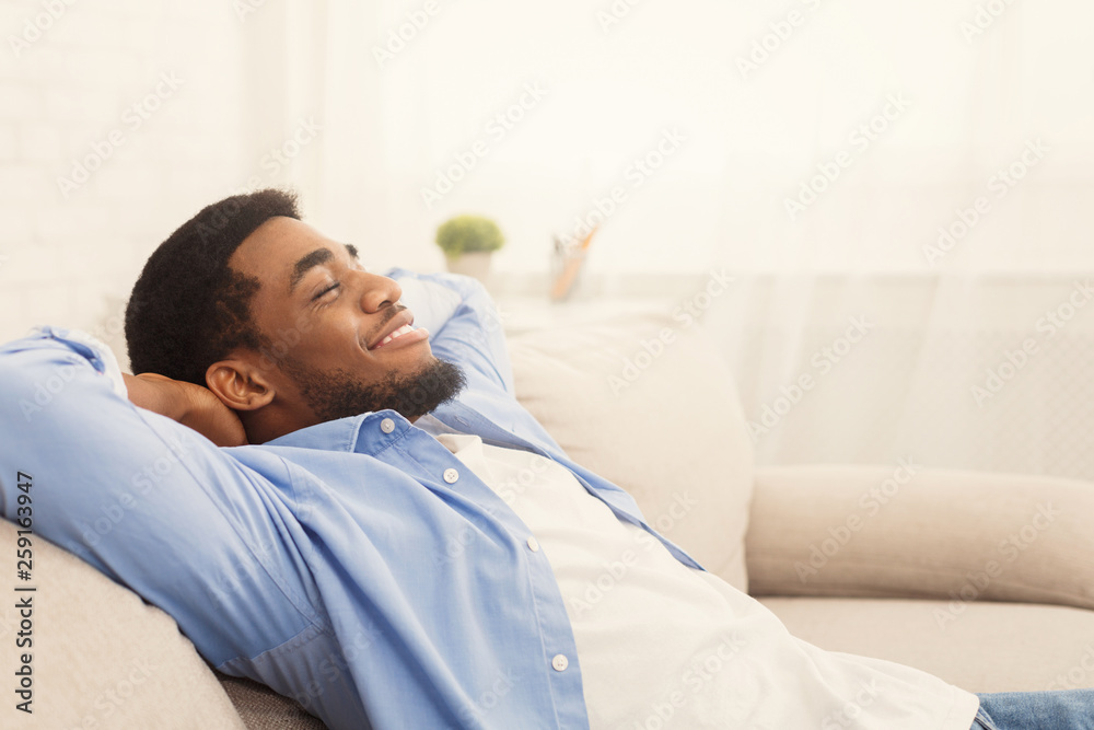 Handsome african-ameriacn man relaxing on sofa at home Handsome african-ameriacn man relaxing on sofa at home