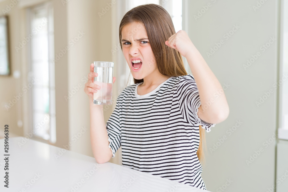 Beautiful young girl kid drinking a fresh glass of water annoyed and frustrated shouting with anger, crazy and yelling with raised hand, anger concept Beautiful young girl kid drinking a fresh glass of water annoyed and frustrated shouting with anger, crazy and yelling with raised hand, anger concept