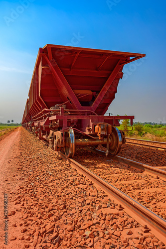 A freight train carrying bauxite in railway carriages for transhipment into a capesize bulk carrier ships by covered conveyor belt mechanism in the Kamsar, Guinea, Africa. photo