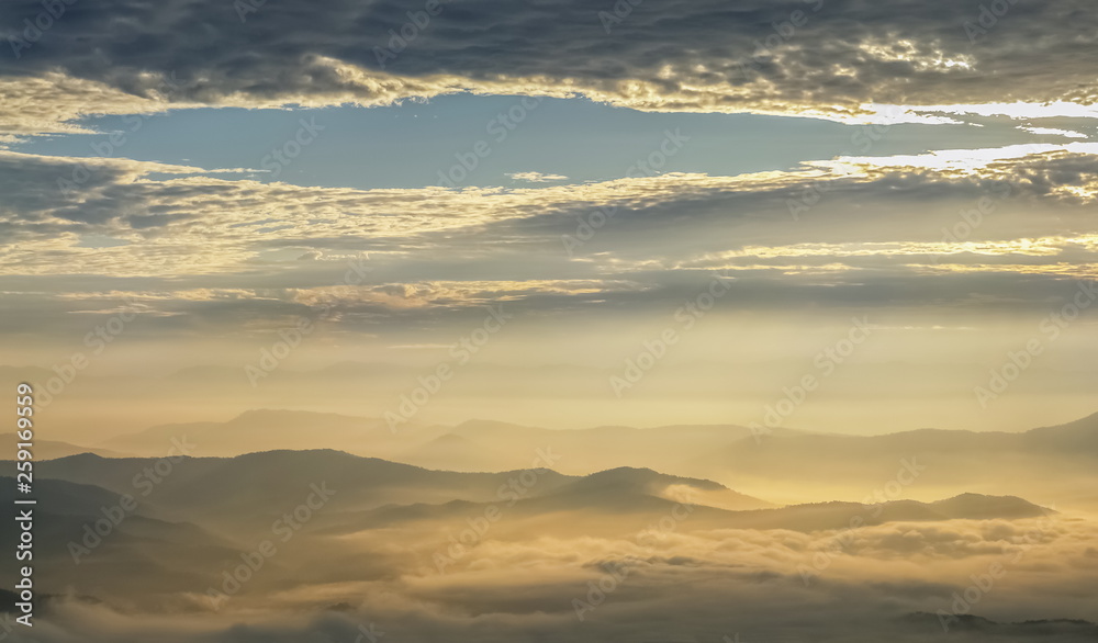 Mountain view morning of the hills around with sea of mist and soft yellow sun light in the sky background, sunrise at Doi Samur Dao, Sri Nan National Park, Nan, Thailand. Mountain view morning of the hills around with sea of mist and soft yellow sun light in the sky background, sunrise at Doi Samur Dao, Sri Nan National Park, Nan, Thailand.