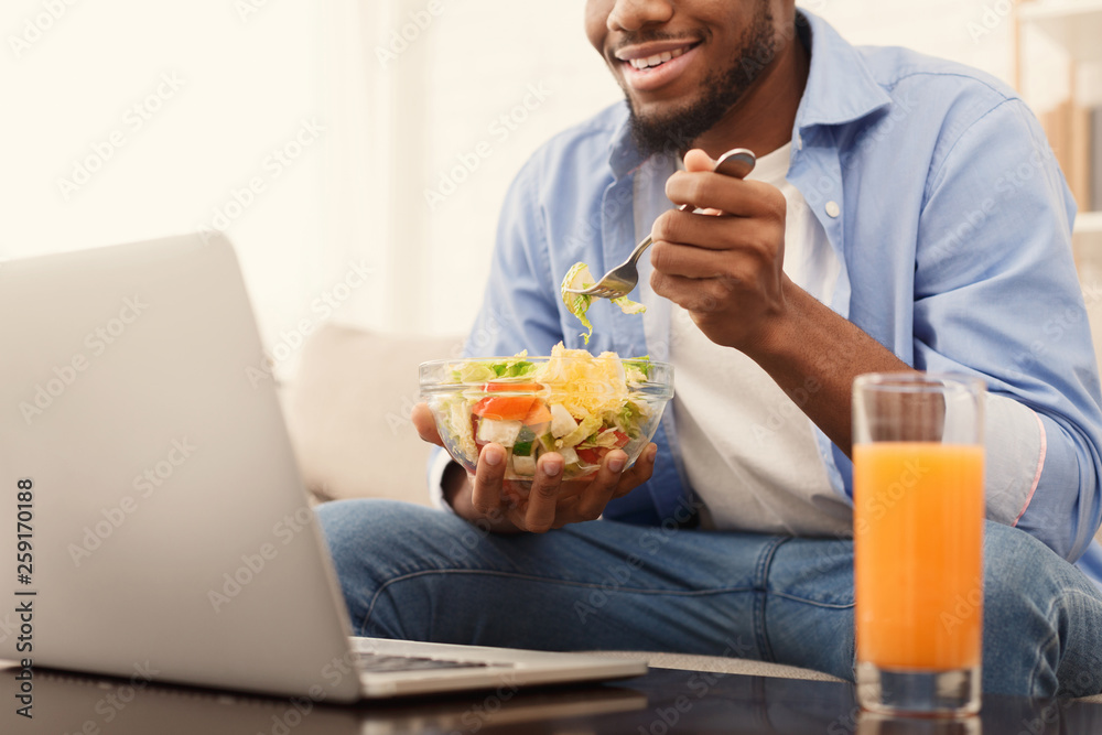 Cheerful african-american man eating healthy lunch at home Cheerful african-american man eating healthy lunch at home