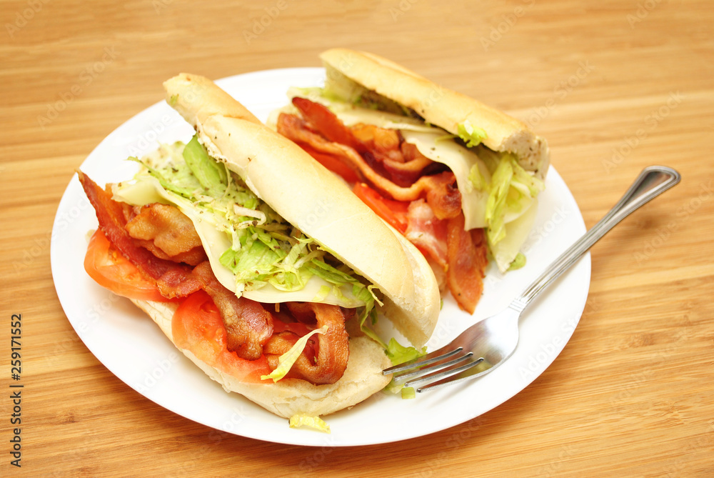 Bacon, Lettuce, & Tomato Deli Sandwich on a White Plate Bacon, Lettuce, & Tomato Deli Sandwich on a White Plate