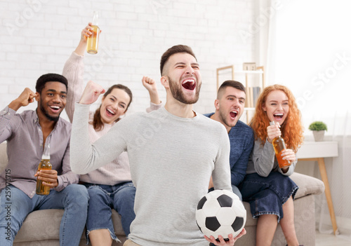 Happy football fans watching match on tv
