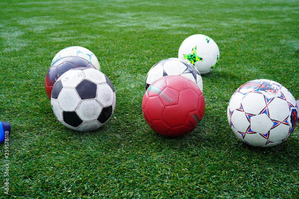 Soccer balls on a soccer field during practice time. Ball on green grass of stadium. Soccer Football on white line of Soccer field background. Soccer balls on a soccer field during practice time. Ball on green grass of stadium. Soccer Football on white line of Soccer field background.