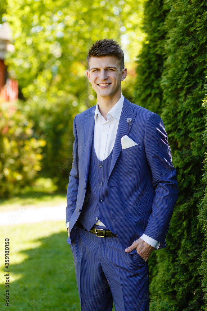 portrait of a positive groom in a blue suit portrait of a positive groom in a blue suit