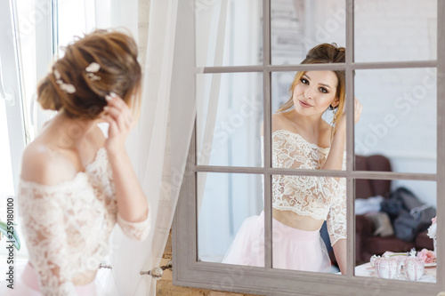 cute bridesmaid looks at herself in the mirror