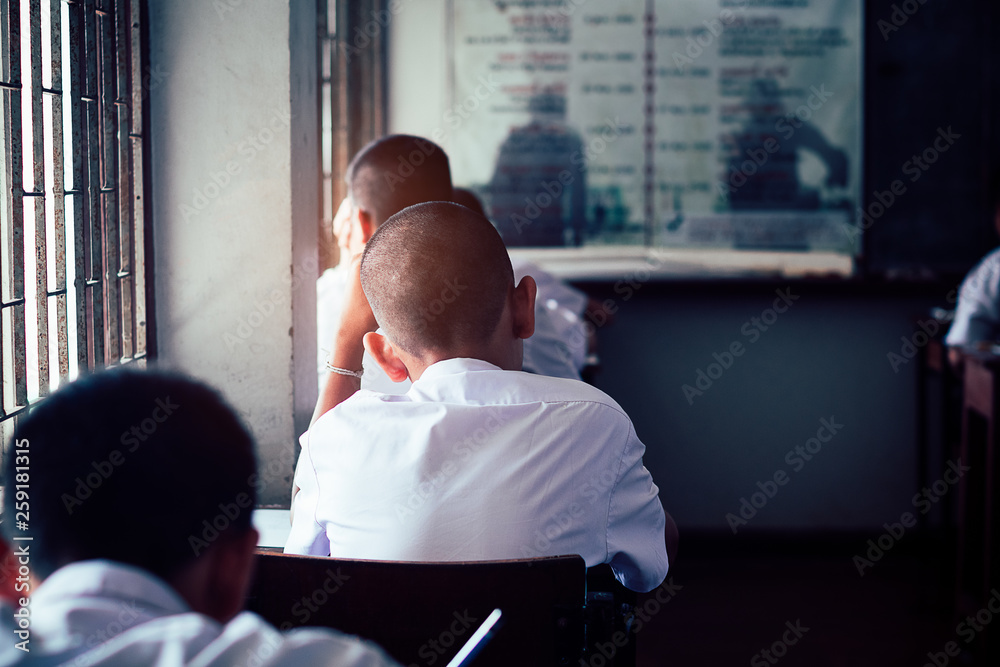 Fototapeta premium Students reading and writing answer doing exam in classroom with stress