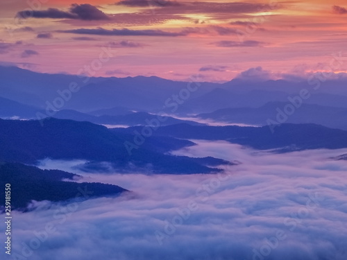 Mountain view morning of the hills around with sea of mist and colorful red sun light in the sky background, twilight at Doi Samur Dao, Sri Nan National Park, Nan, Thailand.